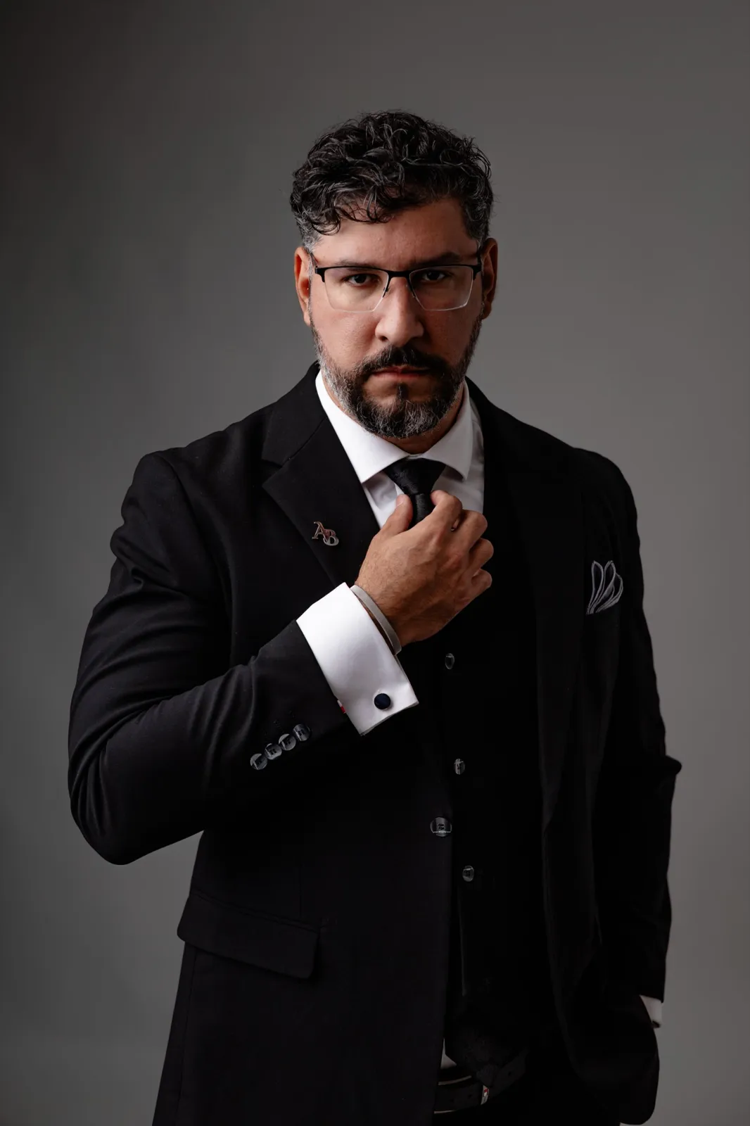 Alexandre D. Bugarin Jr. de terno preto, ajustando a gravata
